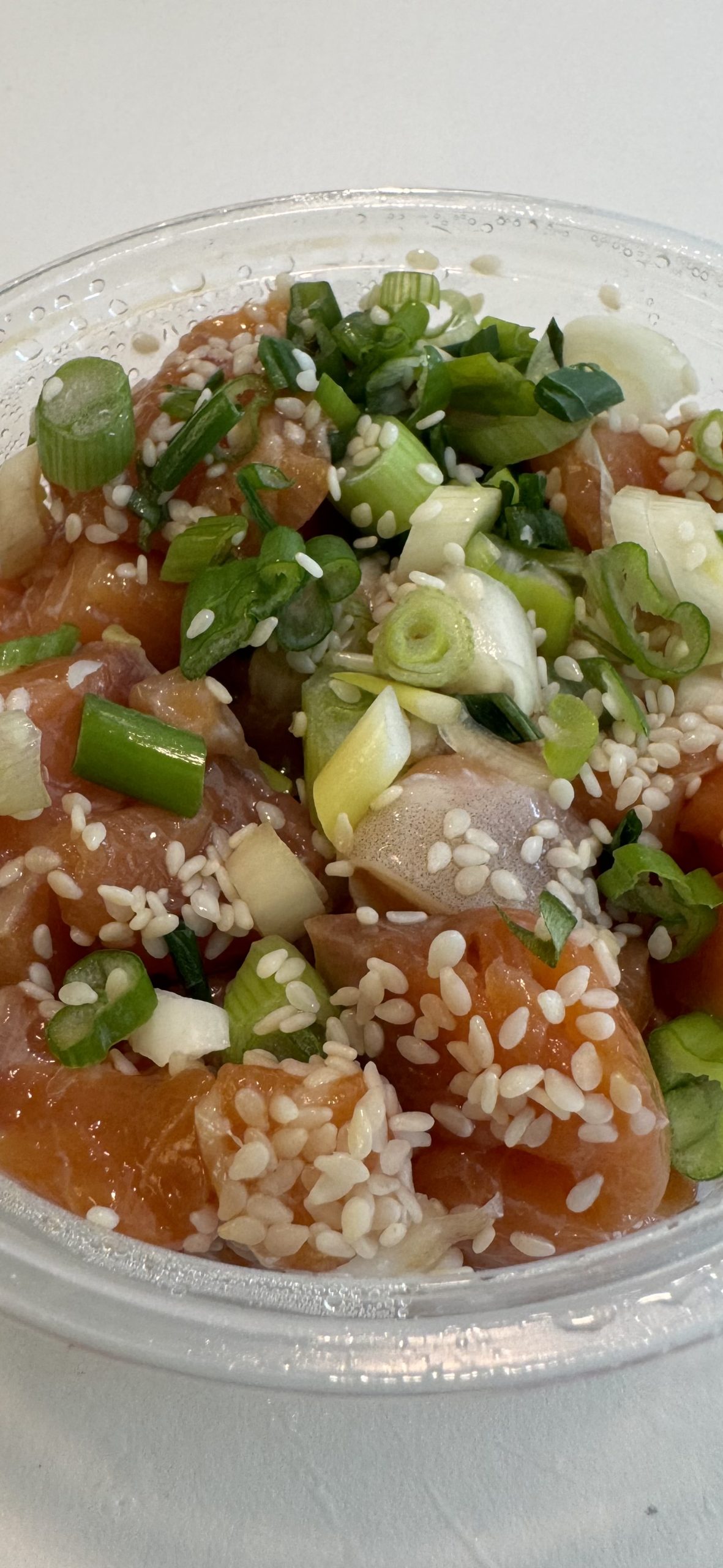 Fresh salmon poke prepared with green onion and sesame
