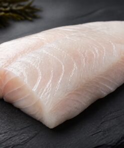 Fresh raw white sea bass fillet on dark slate with lemon